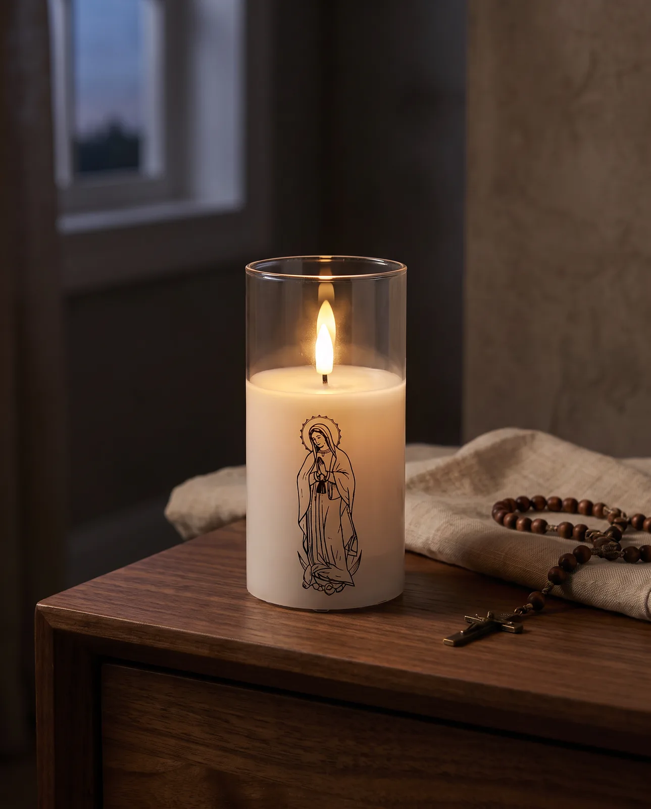 White glass saint candle glowing in the evening
